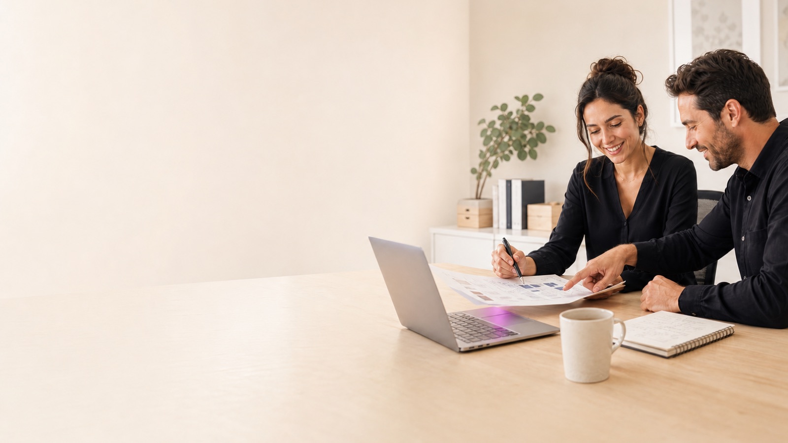 Two anonymous GTM operators reviewing a campaign plan together at a bright desk.